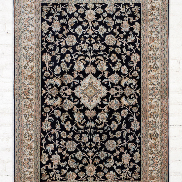 A premium silk carpet with a classic blue medallion design, handcrafted in Kashmir for a luxurious and timeless look.